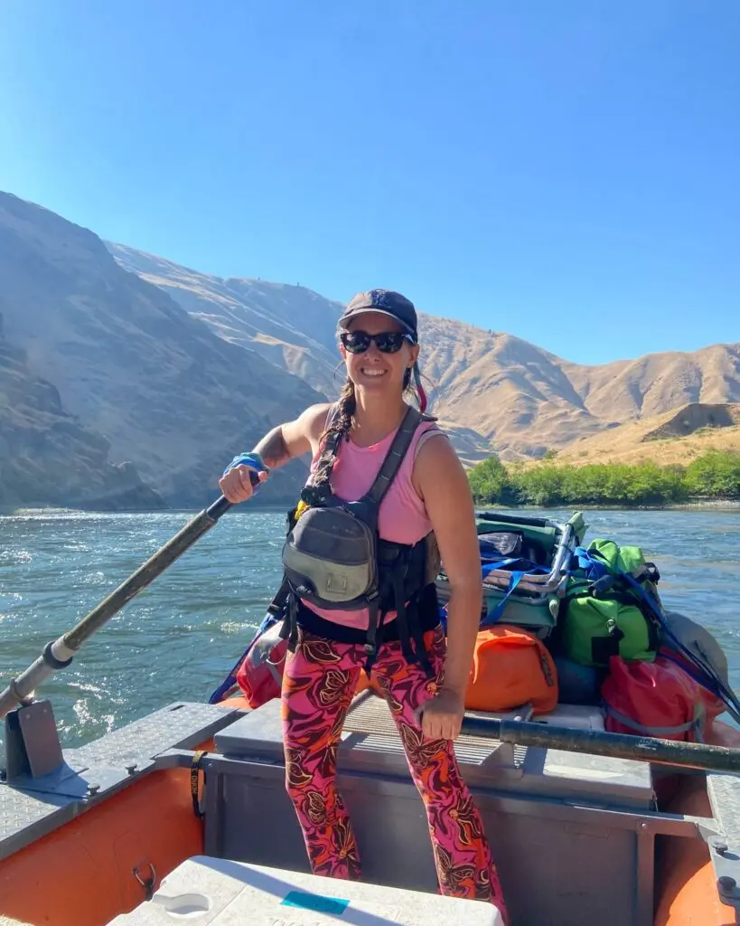 A women oarsman smiling on her raft.